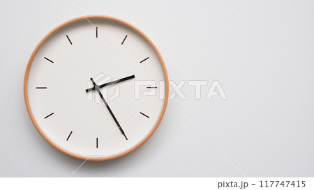 Minimalist wooden Wall Clock on White Wooden Surface with Space for Text. Time Set at 14.25, 02.25 117747415