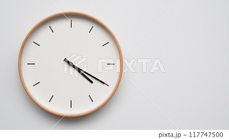 Minimalist wooden Wall Clock on White Wooden Surface with Space for Text. Time Set at 16.20/04.20 117747500