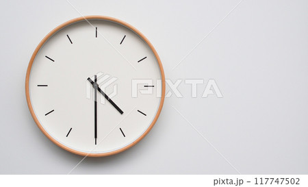 Minimalist wooden Wall Clock on White Wooden Surface with Space for Text. Time Set at 16.30/04.30 117747502