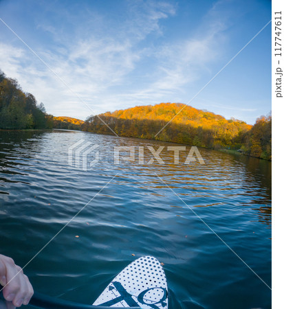 Paddleboarding on a Serene Autumn Lake Paddleboarding on a Serene Autumn Lake 117747611