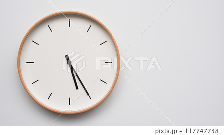 Minimalist wooden Wall Clock on White Wooden Surface with Space for Text. Time Set at 17.25/05.25 Minimalist wooden Wall Clock on White Wooden Surface with Space for Text. Time Set at 17.25/05.25 117747738