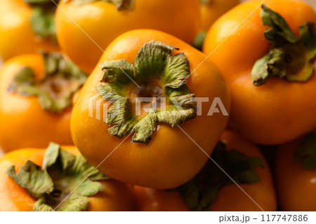 Ripe persimmon fruit texture background 117747886