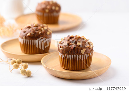Chocolate almond muffin on wooden plate with white background 117747929