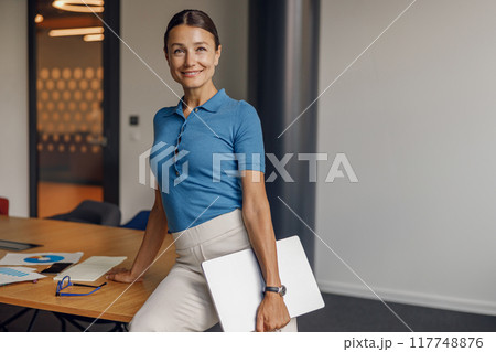 A confident and successful professional woman is depicted in a modern office setting 117748876