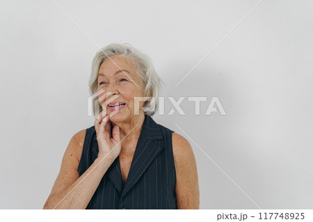 A Thoughtful Senior Woman Dressed in Comfortable Casual Attire, Radiating Confidence and Style A Thoughtful Senior Woman Dressed in Comfortable Casual Attire, Radiating Confidence and Style 117748925