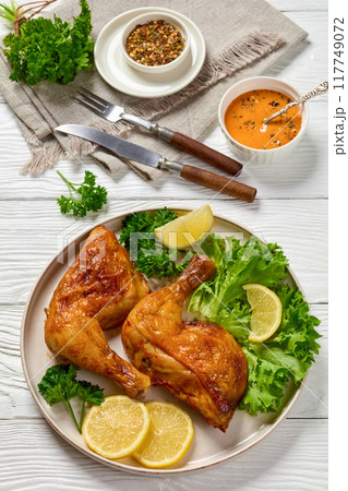fried chicken legs with lettuce, lemon on plate 117749072