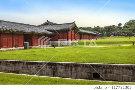 Red wooden buildings surrounding Changgyeonggung Palace, showcasing traditional Korean architecture, beautifully contrast with the green grass on the grounds. Red wooden buildings surrounding Changgyeonggung Palace, showcasing traditional Korean architecture, beautifully contrast with the green grass on the grounds. 117751303