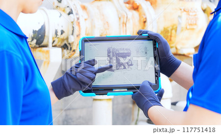 タブレットを見ながら配管を点検する作業員 タブレットを見ながら配管を点検する作業員 117751418