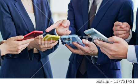 スマホを使うビジネスパーソンのグループ スマホを使うビジネスパーソンのグループ 117751451