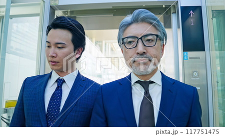 エレベーターに乗る二人のビジネスパーソン エレベーターに乗る二人のビジネスパーソン 117751475