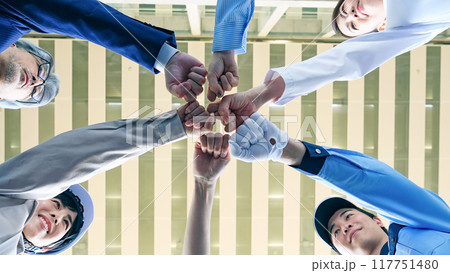 円陣を組む様々な職業の人々のチームワークイメージ（ビジネスマン・エンジニア・研究者・警備員） 117751480