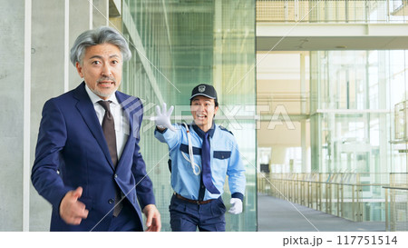 警備員に追いかけられるミドル男性ビジネスパーソン 117751514