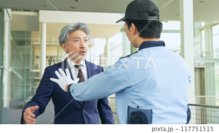 警備員に止められるミドル男性 117751515