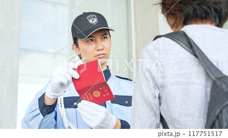 パスポートをチェックする警備員 117751517