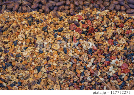 Colorful assortment of dried fruits, nuts, and seeds at local market, rich variety of textures and colors Colorful assortment of dried fruits, nuts, and seeds at local market, rich variety of textures and colors 117752275