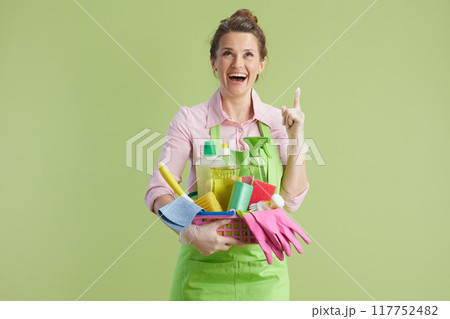 smiling modern woman pointing on copy space on green background 117752482