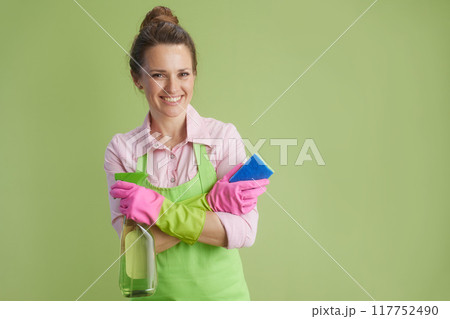 smiling woman in green apron and rubber gloves against green 117752490
