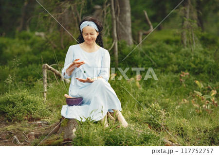 Senior woman with hindu things. Lady in a blue dress. Brunette sitting. Senior woman with hindu things. Lady in a blue dress. Brunette sitting. 117752757