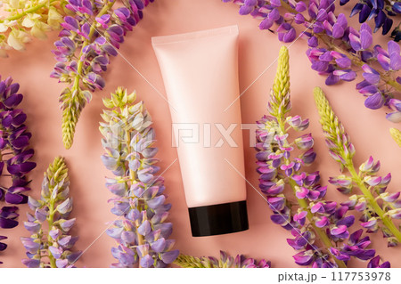 cosmetic moisturizer pink tube bottle with black cap and lupine flowers a lot on pink background. sunscreen, sunblock or sun cream. skincare, gel, shampoo, facial skin cleanser, toothpaste. mockup cosmetic moisturizer pink tube bottle with black cap and lupine flowers a lot on pink background. sunscreen, sunblock or sun cream. skincare, gel, shampoo, facial skin cleanser, toothpaste. mockup 117753978