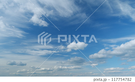 Clouds move in the blue sky. Tropical sky at day time, only white and blue colors. Semi-transparent layers on different height. Timelapse. Clouds move in the blue sky. Tropical sky at day time, only white and blue colors. Semi-transparent layers on different height. Timelapse. 117754782