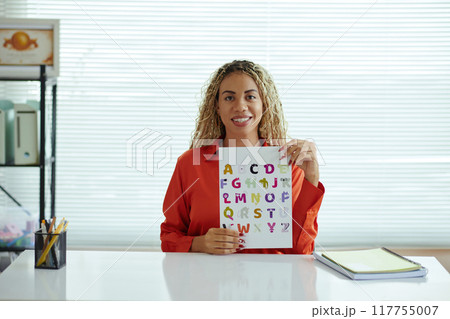 Portrait of Woman Holding Alphabet Sheet in Classroom 117755007