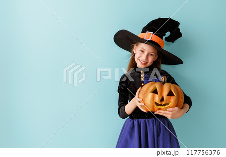 girl in witch costume with Halloween pumpkin girl in witch costume with Halloween pumpkin 117756376