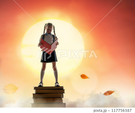 child on the tower of books child on the tower of books 117756387