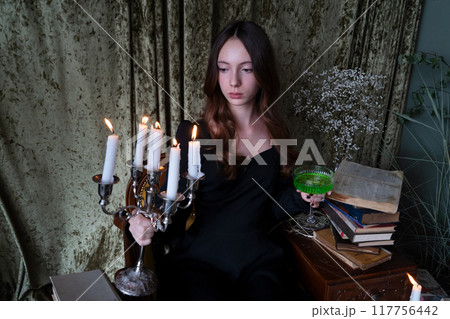 An Ethereal and Enigmatic Portrait of a Young Woman Graced by an Elegant Candelabra While Dressed in Dark Attire An Ethereal and Enigmatic Portrait of a Young Woman Graced by an Elegant Candelabra While Dressed in Dark Attire 117756442