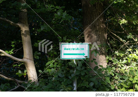 Picture of a green framed sign with a white base and the inscription recreation in a dense forest 117756729