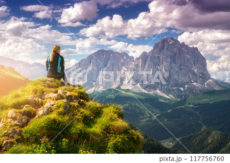 Sitting girl on the peak in beautiful alpine mountain valley 117756760