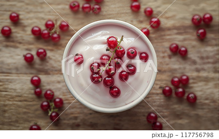 Greek yogurt with red currant berries on wooden table with copy space, top view Greek yogurt with red currant berries on wooden table with copy space, top view 117756798