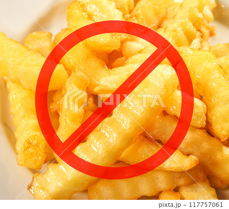 Red circle with a line through it over delicious crinkle-cut fries, indicating a prohibition of French fries Red circle with a line through it over delicious crinkle-cut fries, indicating a prohibition of French fries 117757061