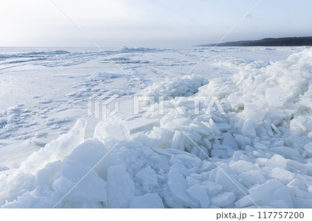 Winter landscape with frozen sea coast and ice hummocks 117757200