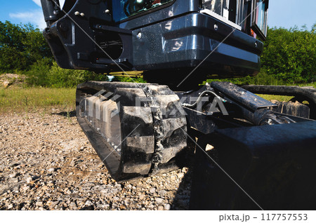Bucket and rubber crawler tracks of a small excavator close-up Bucket and rubber crawler tracks of a small excavator close-up 117757553