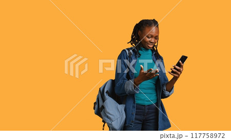 Upset african american woman arguing with friends during teleconference meeting on smartphone, studio background. Annoyed girl fighting on mobile phone videocall with mates, camera B 117758972