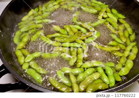 枝豆を茹でる。調理シーン。フライパンでゆでるエダマメ。 枝豆を茹でる。調理シーン。フライパンでゆでるエダマメ。 117760222