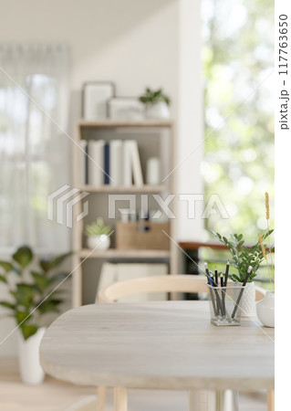 A space for displaying products on a wooden table in a contemporary bright room at home. A space for displaying products on a wooden table in a contemporary bright room at home. 117763650