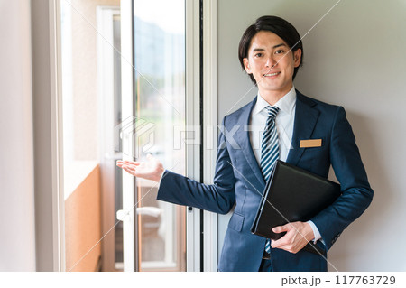 窓・ドア・サッシ・ガラス戸・鍵を案内するビジネスマン（樹脂サッシ・省エネ基準） 117763729