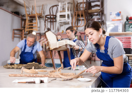 Restorer woman carefully cleans dirt and dust from carved wooden decor element Restorer woman carefully cleans dirt and dust from carved wooden decor element 117764303