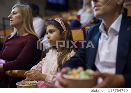 parents with children sitting at movie in cinema parents with children sitting at movie in cinema 117764739