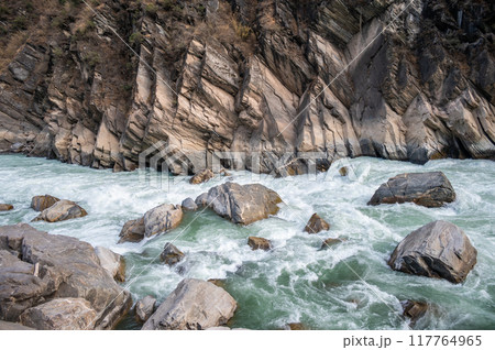 The landscape of Tiger Leaping Gorge in Yunnan province of China. Scenic spot where a tiger is said to have leaped across the river, thus giving the gorge its name. The landscape of Tiger Leaping Gorge in Yunnan province of China. Scenic spot where a tiger is said to have leaped across the river, thus giving the gorge its name. 117764965