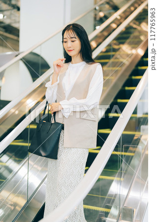 エスカレーターに乗る女性 117765963