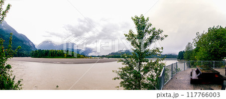 River with cloud covered green mountains in the background 117766003