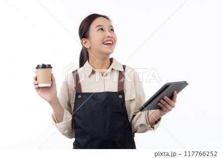 Portrait young barista woman holding coffee cup and tablet wearing apron with excited isolated. 117766252