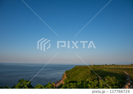 夕日を浴びる能取岬から知床、斜里方面の光景 117766729