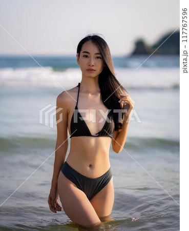海辺に立つ水着の若い女性 117767596