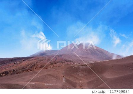 エトナ山の煙る火口と青空 117769084