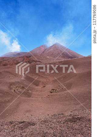 エトナ山の煙る火口と青空 117769086