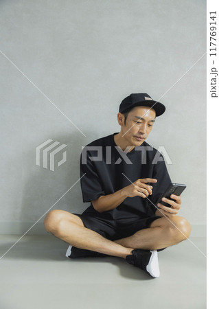 座っているキャップの男性 117769141
