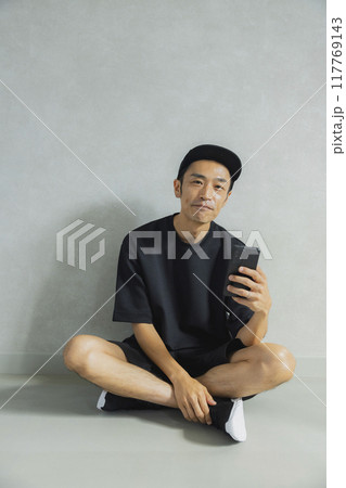 座っているキャップの男性 117769143
